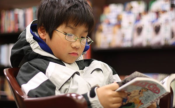 Young boy reading manga
